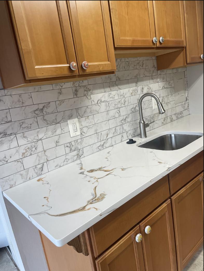 Tile backsplash and quartz countertop with a stainless sink
