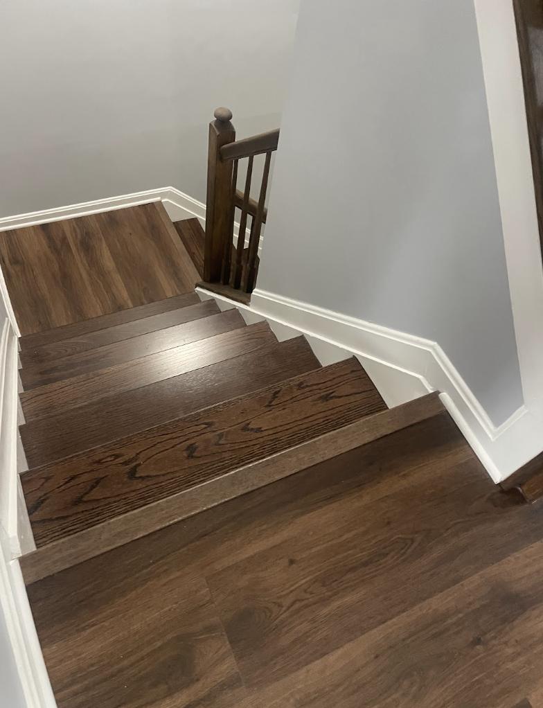 Stair landing with stained treads and white baseboard
